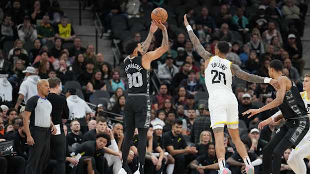 Dec 26, 2023; San Antonio, Texas, USA; San Antonio Spurs forward Julian Champagnie (30) shoots over Utah Jazz forward John Collins (20) in the first half at the Frost Bank Center.
